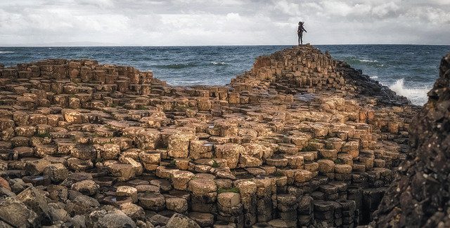 A girl standing on the rocks and enjoying the sea